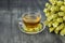 Greek traditional herbal tea in transparent cup. Bunch of mountain tea Malotira and mug with hot tea. Mountain tea sideritis.