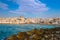 Greek whitewashed houses, church and restaurants by seafront on sunny day, Naoussa, Paros island, Greece