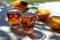 Greek wine in 2 glasses, fresh ripe orange served in garden in sun lights