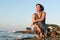 Greek woman in blue sitting on a beach