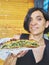 Greek woman eating a traditional Spanakotiropita, Spinach and Feta pie.