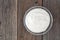 Greek yogurt in clear bowl, above view on rustic wood