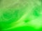 Green abstract background. Close up view. Blurred background. Green acrylic paint dissolving into water, abstract