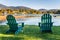 Green Adirondack Chairs a Facing a Mountain Lake