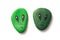 Green aliens painting on stone pebbles on white background