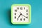 Green analog clock on blue background