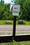 A green angle parking sign with trees in the background