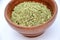 The  green anise in the wooden bowl isolated in  white background