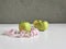 .Green Apple with centimeter tape, three green apples against a gray wall, double measuring tape, serpentine with inches