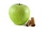 green apple with cinnamon pods on white