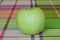 Green apple on a colored tablecloth