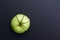 Green apple cutting in the shape of pie chart on back board.