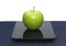 Green apple on kitchen scales closeup