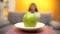 Green apple lying on plate, woman on background, exhausting vegan diet, slimming