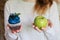 Green apple and sugar cupcake in the hands, the dilemma of what to choose, the concept of healthy eating and lifestyle, the proble