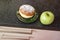 green apple and sugar donut on the table, the dilemma of what to choose, the concept of healthy eating and lifestyle, the problem