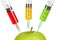 Green apple with three syringes inserted