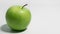 Green apple on white background with space to right