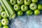 Green apples, celery and limes on a concrete background. Detox program, diet plan, weight loss. Flat lay composition. Top view