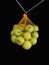 Green apples in a grid isolated on black. Ripe fruits in a string bag. Apple variety