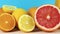 Green apples, lemons, oranges, strawberries, coconut and kiwi close up on blue backgroundClose up of sliced grapefruit, lemon and