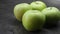 Green apples lie on the table in the kitchen