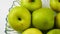 Green apples on a transparent plate.Rotate,closeup.Wegetarianskie,diet product.