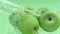 Green Apples under a stream of water with traces of transparent bubbles on a green background. 3D Rendering