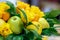 Green apples, yellow lemon, kumquat and yellow roses in the form of the handmade bouquet