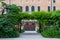 a green arch made of trees in front of the entrance to the house in the Giardini Reali of Venice
