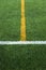 Green artificial grass turf soccer football field with white and yellow line boundary
