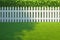 Green artificial turf Wide angle view of white picket fence yard