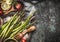 Green asparagus cooking preparation with cooking spoon and ingredients on rustic background, top view