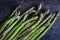 Green asparagus on a dark background. Raw food concept. The vegetable is rich in fiber.