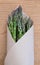 Green asparagus from a farmers market in brown paper packaging -