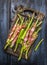 Green asparagus with parma ham on old gutting board, , rustic blue wooden background