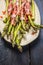 Green asparagus with parma ham in plate on rustic blue wooden background