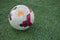 Green astroturf with white colorful soccer ball European football