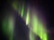 Green aurora borealis curtains on night sky