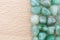 Green Aventurine heap jewel on half light varnished wood texture