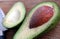 Green avocado with bone lying on a cutting board