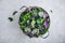 Green baby kale leaves in white colander on gray stone background. Ingredient for healthy  smoothie, salads or pesto sauce