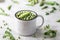 Green baby peas in pan on white background