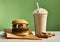 On a green background a hamburger, a shake with cream and fries