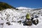 Green backpack on the snow covered volcanic rock of Etna Park
