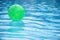 Green ball floating in swimming pool