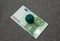 Green ball of thread is on the one hundred euro. In the center of the banknote. The background is fabric gray
