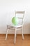 Green balloon on a white chair