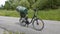 Green barrel on black bicycle in sunny asphalt road