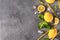 Green Basil, ice cubes, yellow tubes  , yellow whole lemons and slices, on a gray